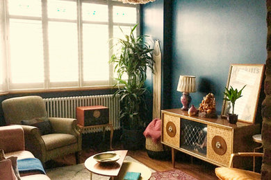 Photo of a medium sized midcentury open plan living room in London with blue walls, a two-sided fireplace, a brick fireplace surround, no tv and brown floors.