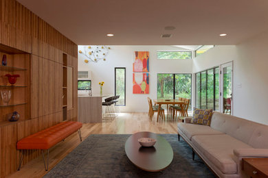 Foto de salón para visitas abierto moderno grande sin chimenea con paredes marrones, suelo de madera clara, televisor retractable, suelo marrón y madera