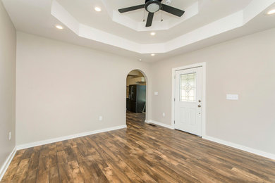 Ejemplo de salón cerrado de estilo americano de tamaño medio con suelo laminado, suelo marrón y casetón