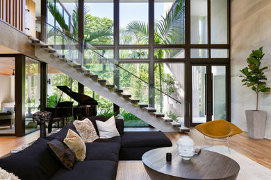 Example of a trendy open concept medium tone wood floor and brown floor living room design in Miami with beige walls
