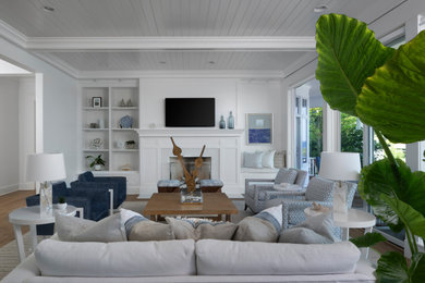 Example of a mid-sized beach style open concept light wood floor living room design in Other with white walls, a standard fireplace and a stone fireplace