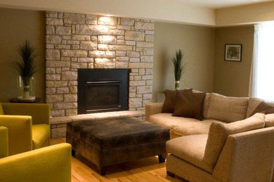 Example of a mid-sized trendy formal and enclosed medium tone wood floor living room design in Calgary with green walls, a standard fireplace and a wood fireplace surround
