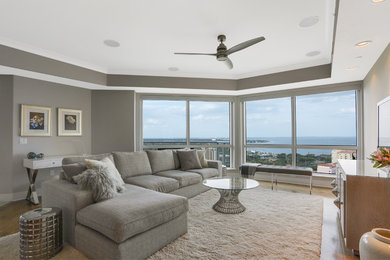 Mittelgroßes, Offenes, Repräsentatives Modernes Wohnzimmer ohne Kamin mit grauer Wandfarbe, braunem Holzboden, freistehendem TV und braunem Boden in Tampa