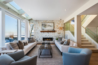 Example of a trendy formal medium tone wood floor and brown floor living room design in Vancouver with beige walls, a ribbon fireplace, a stone fireplace and no tv