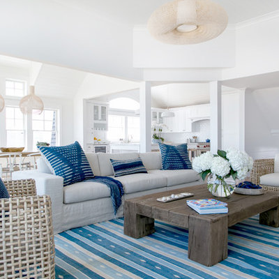 Living room - coastal open concept medium tone wood floor and brown floor living room idea in New York with white walls