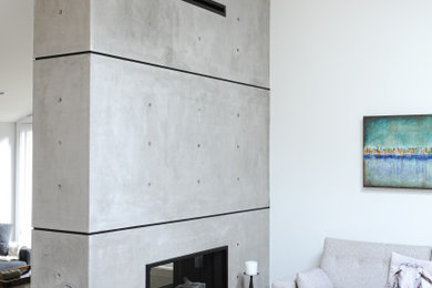 Inspiration for a contemporary living room remodel in Vancouver with a two-sided fireplace and a concrete fireplace