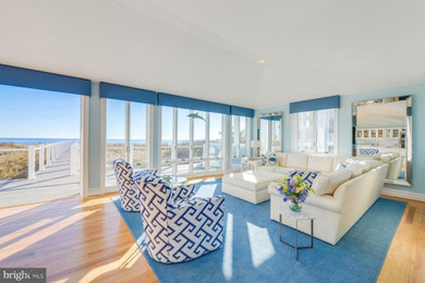 Foto di un grande soggiorno stile marinaro aperto con pareti blu, parquet chiaro e TV a parete