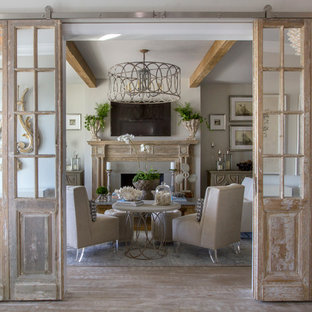 Immagine di un soggiorno shabby-chic style chiuso con pareti grigie, parquet chiaro, camino classico e TV a parete