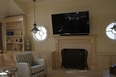 Imagen de salón marinero grande con paredes beige, todas las chimeneas, marco de chimenea de madera y televisor colgado en la pared