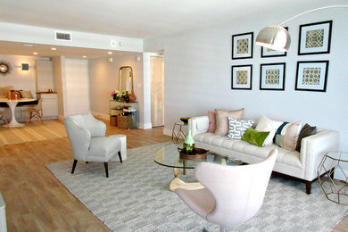 Example of a small beach style open concept laminate floor living room design in Miami with gray walls and a tv stand
