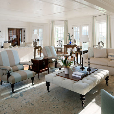 Beach style open concept medium tone wood floor living room photo in Boston with white walls
