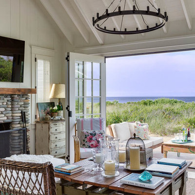 Small beach style open concept light wood floor living room photo in Other with white walls, a standard fireplace, a stone fireplace and a wall-mounted tv
