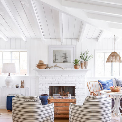 Inspiration for a small coastal open concept light wood floor living room remodel in Los Angeles with white walls, a standard fireplace, a brick fireplace and no tv