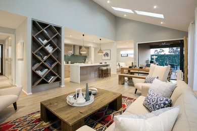 Mittelgroßes, Offenes Modernes Wohnzimmer mit blauer Wandfarbe, hellem Holzboden und braunem Boden in Melbourne