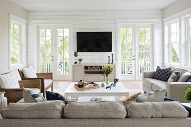 Foto di un grande soggiorno costiero aperto con pareti bianche, parquet chiaro, TV a parete, pavimento beige e pareti in perlinato
