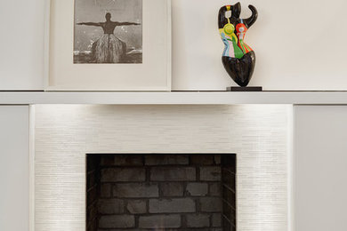 ロンドンにあるお手頃価格の小さなコンテンポラリースタイルのおしゃれなリビング (白い壁、濃色無垢フローリング、タイルの暖炉まわり、標準型暖炉) の写真