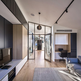 Mid-sized modern formal open concept living room in Melbourne with white walls, medium hardwood floors, a freestanding tv and brown floor.