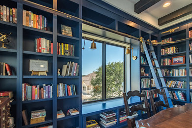 Mid-sized trendy enclosed medium tone wood floor and brown floor living room library photo in Austin with blue walls, no tv and no fireplace