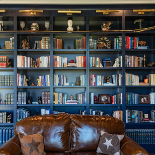 Idee per un soggiorno design di medie dimensioni e chiuso con libreria, pareti blu, pavimento in legno massello medio, nessun camino, nessuna TV e pavimento marrone