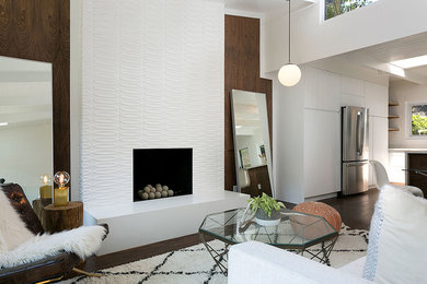 Example of a large transitional formal and open concept dark wood floor and brown floor living room design in San Francisco with beige walls, a standard fireplace, a plaster fireplace and no tv