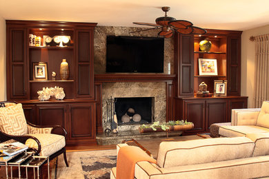 Mittelgroßes, Offenes Klassisches Wohnzimmer mit beiger Wandfarbe, braunem Holzboden, Kamin, Kaminumrandung aus Stein und Multimediawand in Orange County