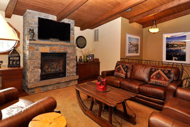 Example of a mid-sized mountain style open concept carpeted living room design in San Francisco with beige walls, a standard fireplace, a brick fireplace and a wall-mounted tv