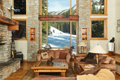 Example of a huge mountain style open concept light wood floor living room design in Other with beige walls, a standard fireplace and a stone fireplace