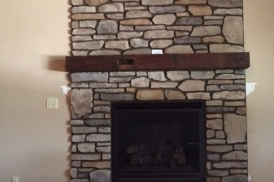 他の地域にある高級なトラディショナルスタイルのおしゃれなリビング (標準型暖炉、石材の暖炉まわり、ベージュの壁、カーペット敷き、ベージュの床) の写真