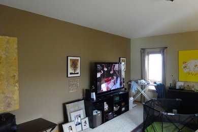 Photo of a small modern enclosed living room in Milwaukee with beige walls, a freestanding tv and carpet.