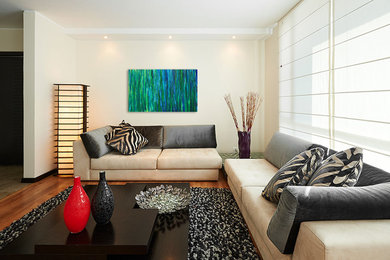 Imagen de salón abierto moderno grande con paredes beige y suelo de madera en tonos medios