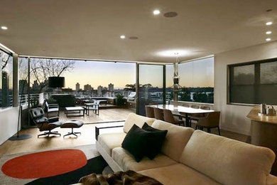 Example of a mid-sized trendy open concept light wood floor living room design in Sydney with white walls