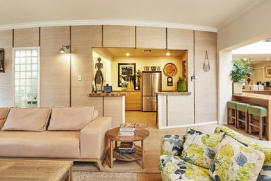 メルボルンにある高級な広いトロピカルスタイルのおしゃれなLDK (ベージュの壁、クッションフロア、薪ストーブ、タイルの暖炉まわり、据え置き型テレビ、ベージュの床) の写真