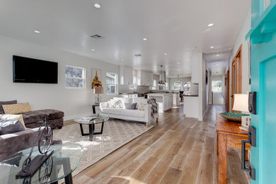Mittelgroßes, Offenes Modernes Wohnzimmer mit weißer Wandfarbe, hellem Holzboden und TV-Wand in Los Angeles