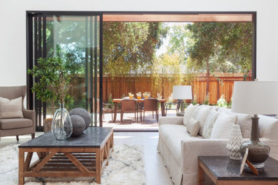Example of a huge minimalist open concept light wood floor living room design in San Francisco with white walls and no tv
