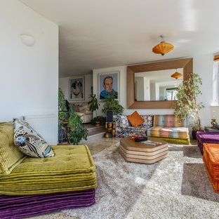 This is an example of a bohemian enclosed living room in Sussex with white walls and carpet.