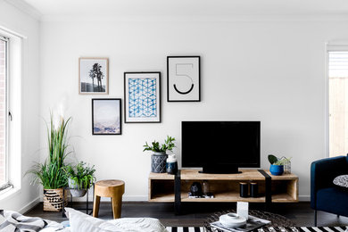 Foto de salón abierto contemporáneo pequeño con paredes blancas, suelo de madera oscura y televisor independiente