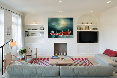 Exemple d'un grand salon chic ouvert avec un mur blanc, parquet clair, une cheminée standard et un téléviseur encastré.