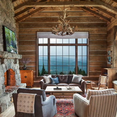 Large mountain style formal light wood floor living room photo in Other with brown walls, a standard fireplace and a stone fireplace