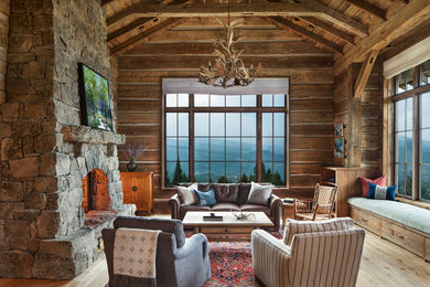 Large mountain style formal light wood floor living room photo in Other with brown walls, a standard fireplace and a stone fireplace