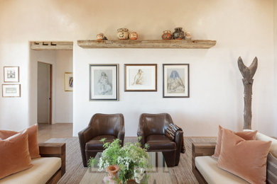 アルバカーキにあるラグジュアリーな広いサンタフェスタイルのおしゃれなLDK (ベージュの壁、茶色い床、表し梁) の写真