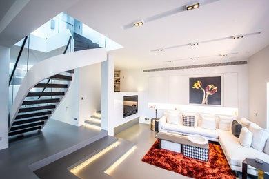 This is an example of a contemporary open plan living room in London with white walls and no fireplace.