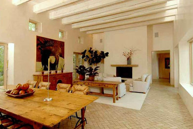 Modelo de salón para visitas abierto de estilo americano grande sin televisor con paredes beige, suelo de ladrillo, todas las chimeneas, marco de chimenea de yeso y suelo marrón