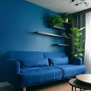 Ispirazione per un piccolo soggiorno industriale chiuso con sala formale, pareti blu, pavimento in laminato, camino bifacciale, cornice del camino in cemento, TV a parete, pavimento marrone e soffitto ribassato