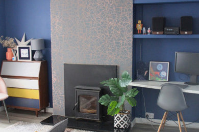 Foto de salón abierto bohemio de tamaño medio sin televisor con paredes azules, suelo laminado, estufa de leña, marco de chimenea de metal y suelo marrón