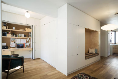 Foto de salón abierto contemporáneo de tamaño medio con paredes blancas, suelo de madera en tonos medios y pared multimedia
