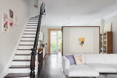 Exemple d'un salon chic avec un mur blanc, un sol en bois brun, une cheminée standard, un manteau de cheminée en pierre, aucun téléviseur et un sol bleu.