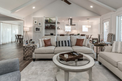 Example of a mid-sized beach style open concept porcelain tile and white floor living room design in Houston with a bar, white walls, a standard fireplace, a brick fireplace and a tv stand
