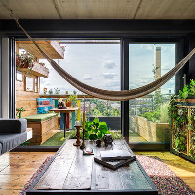 Inspiration for a small industrial enclosed medium tone wood floor and brown floor living room remodel in London with a media wall and gray walls