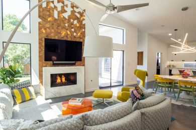 Großes, Offenes Modernes Wohnzimmer mit weißer Wandfarbe, Betonboden, Gaskamin, Kaminumrandung aus Holz, TV-Wand, grauem Boden und gewölbter Decke in Austin
