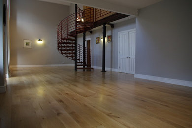 Imagen de salón cerrado industrial extra grande con suelo de madera en tonos medios